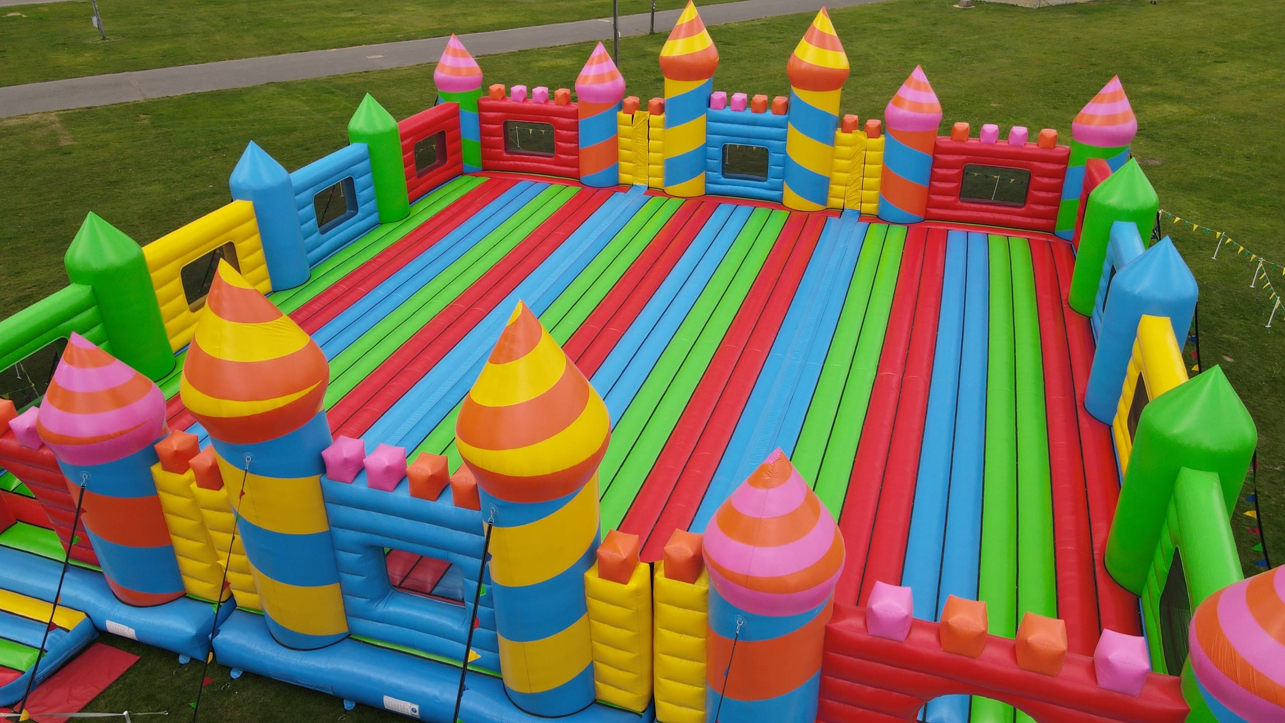 Lab Tour 20 Aerial view of a large colorful inflatable obstacle course set up on a grassy field.