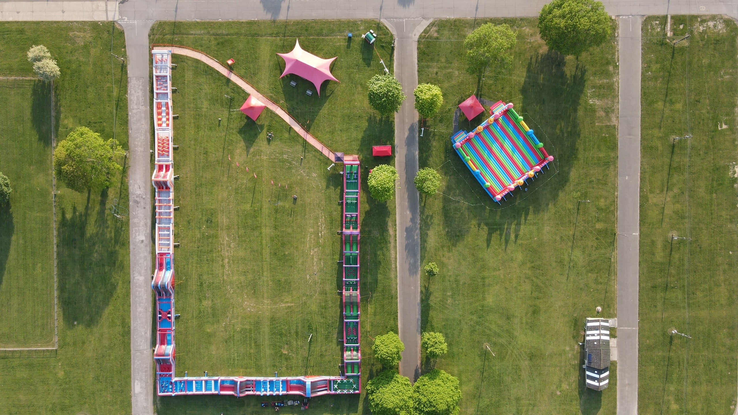 Lab Tour 85 Aerial view of a large colorful inflatable obstacle course set up on a grassy field.