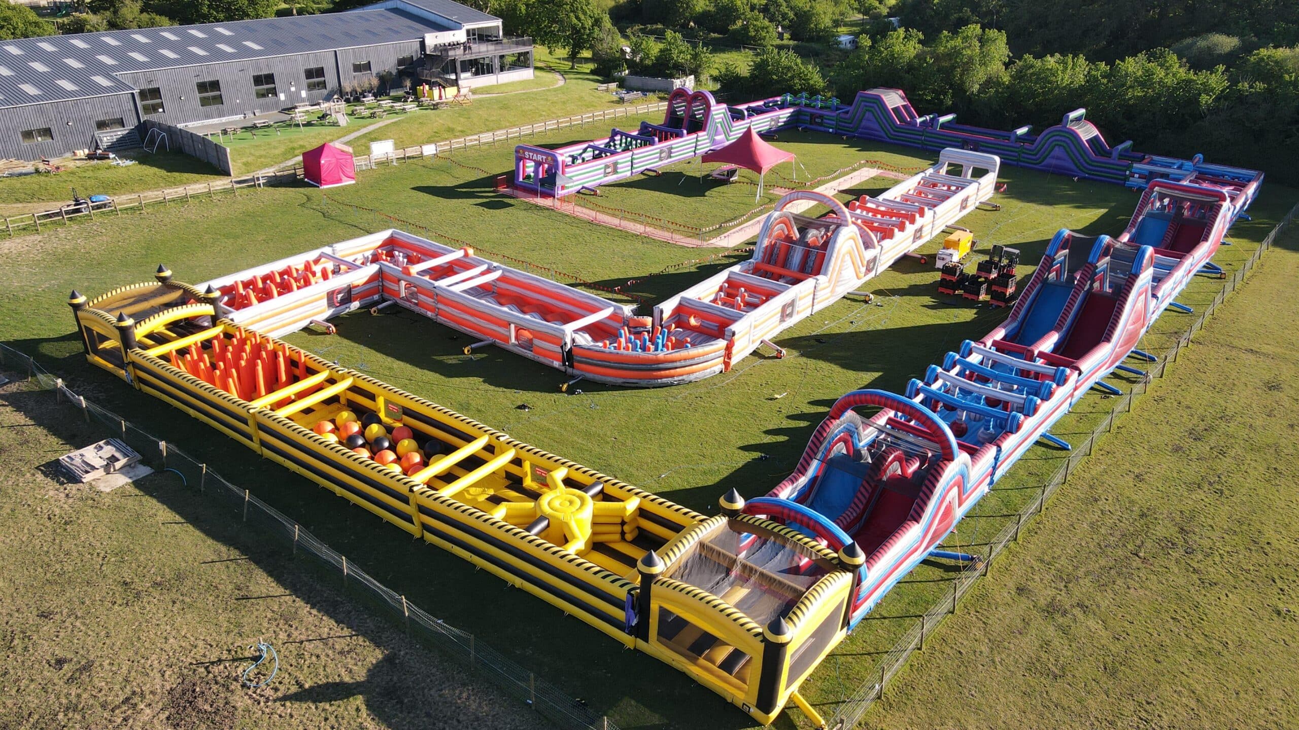 The Labyrinth Challenge IOW 2 Two people play on an inflatable obstacle course with large hanging balls.