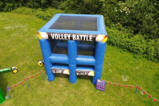 Blue inflatable "Volley Battle" game structure set up on a grassy field.